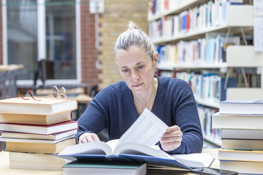 Bibliothek, Frau liest Bücher in der Bibliothek