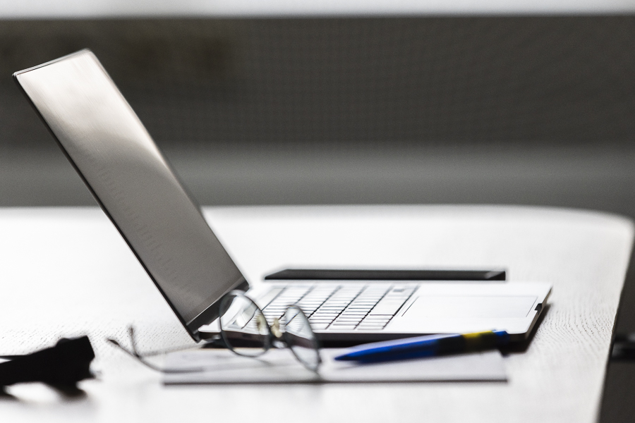 Arbeitsplatz, Laptop auf dem Tisch, Brille, Stift